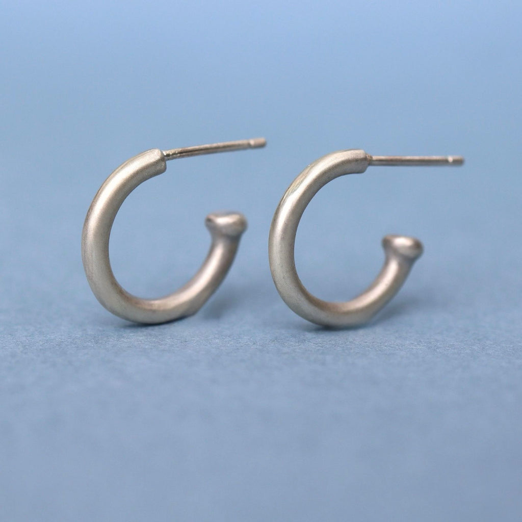 Handcrafted sterling silver huggie hoop earrings with a timeless minimalist design. Lightweight, comfortable, and made for everyday wear.