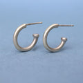 Handcrafted sterling silver huggie hoop earrings with a timeless minimalist design. Lightweight, comfortable, and made for everyday wear.