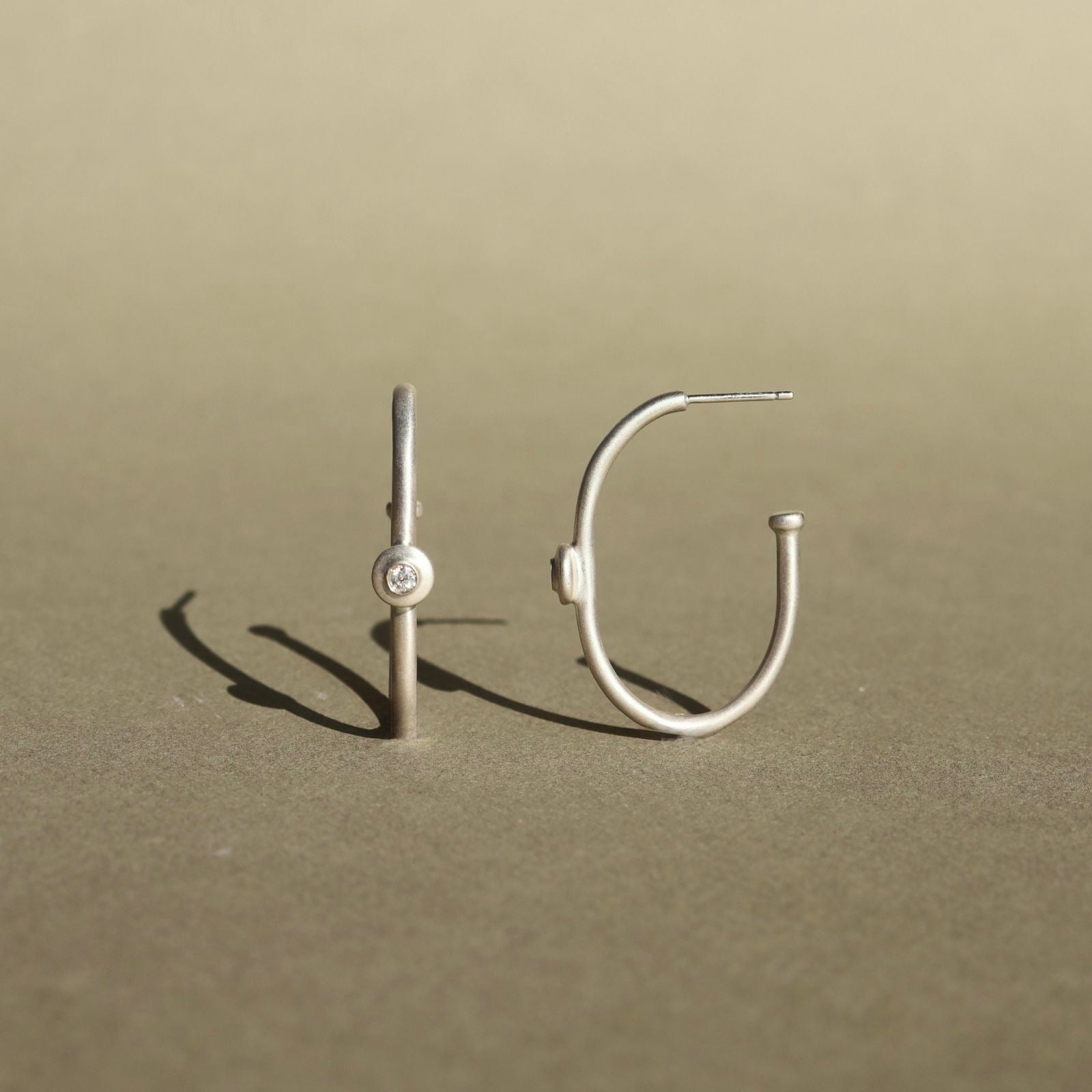 Sterling silver hoop earrings with natural diamond accents and a minimalist design.