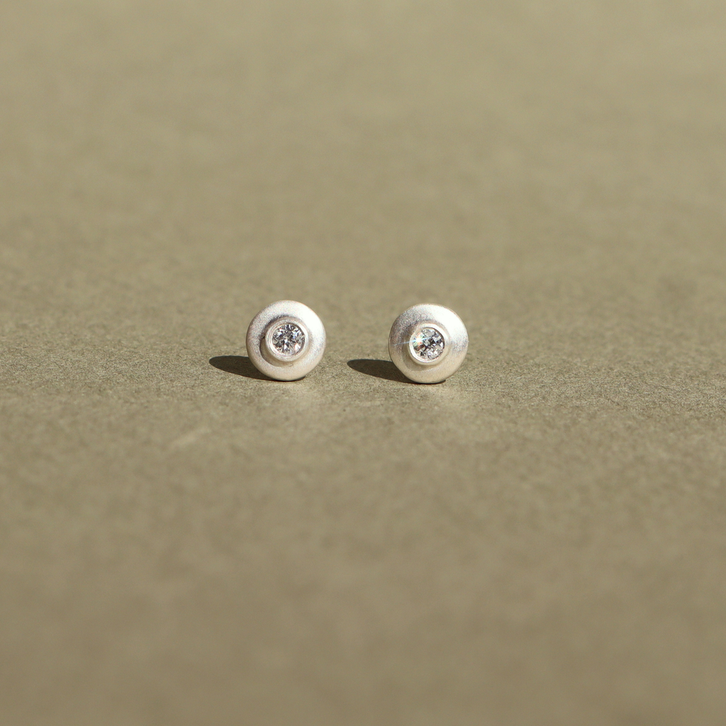 Handcrafted sterling silver stud earrings featuring natural diamonds.