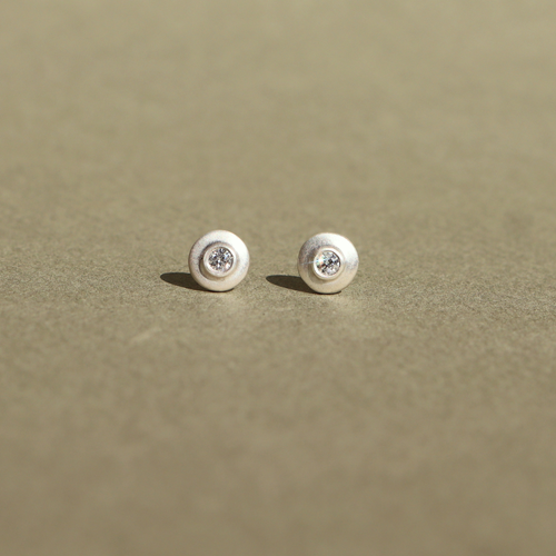 Handcrafted sterling silver stud earrings featuring natural diamonds.