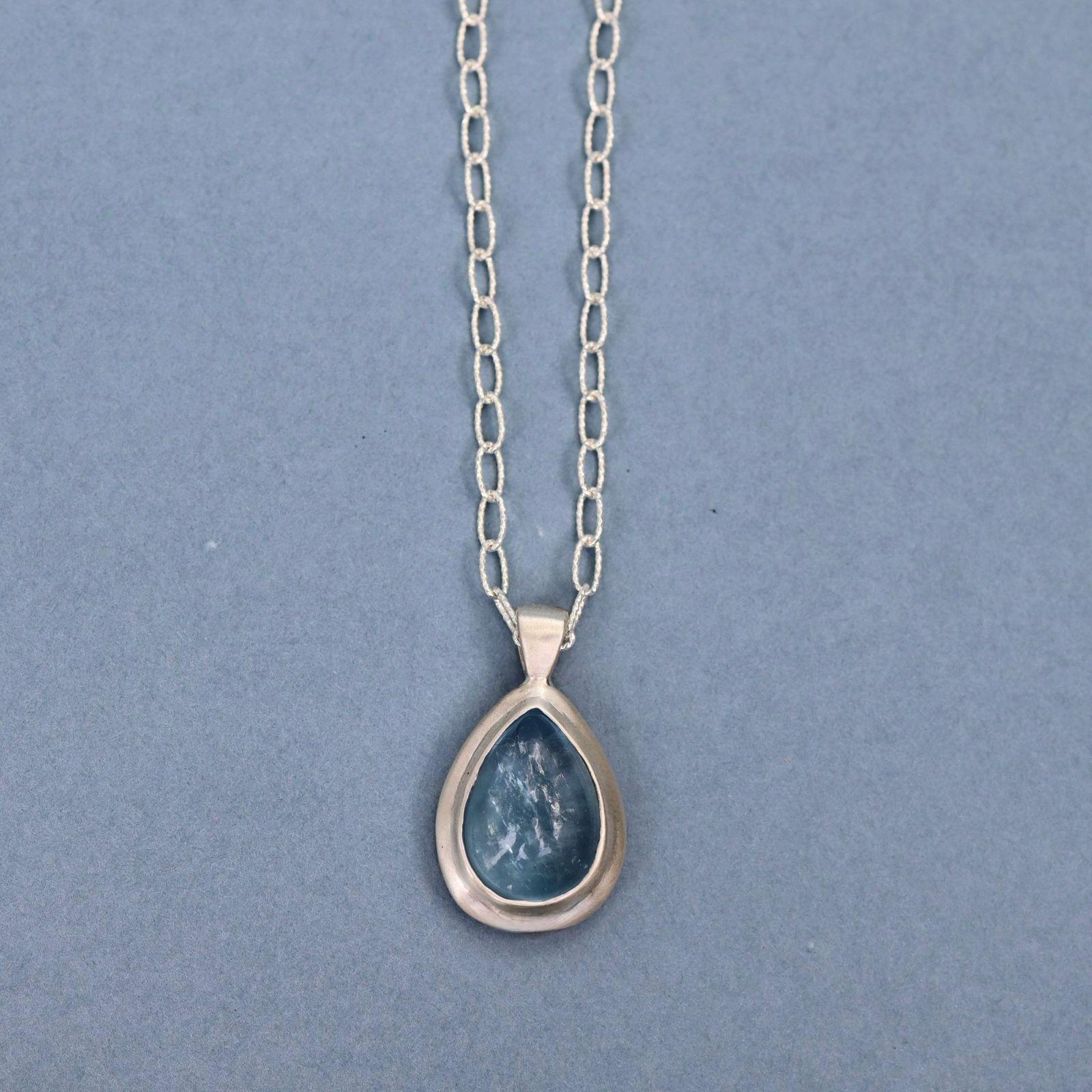 Handcrafted sterling silver pendant featuring a natural aquamarine cabochon on a sterling silver chain.