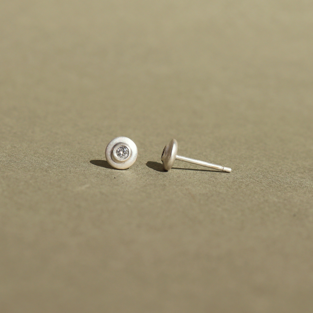 Handcrafted sterling silver stud earrings featuring natural diamonds.