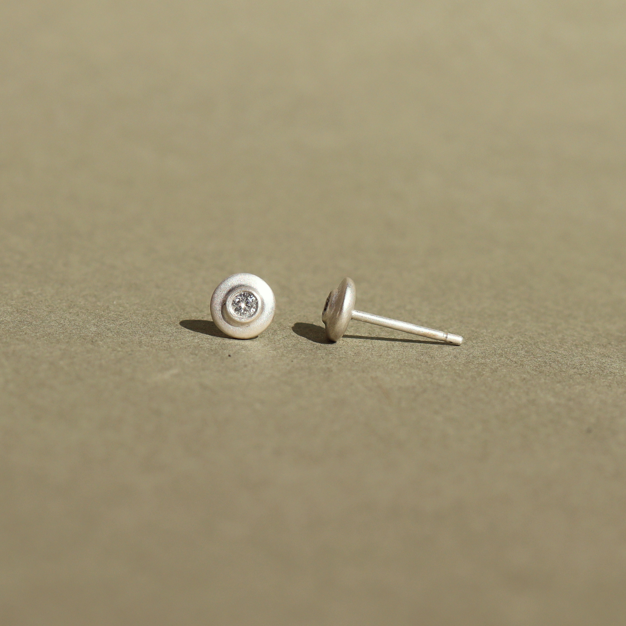 Handcrafted sterling silver stud earrings featuring natural diamonds.