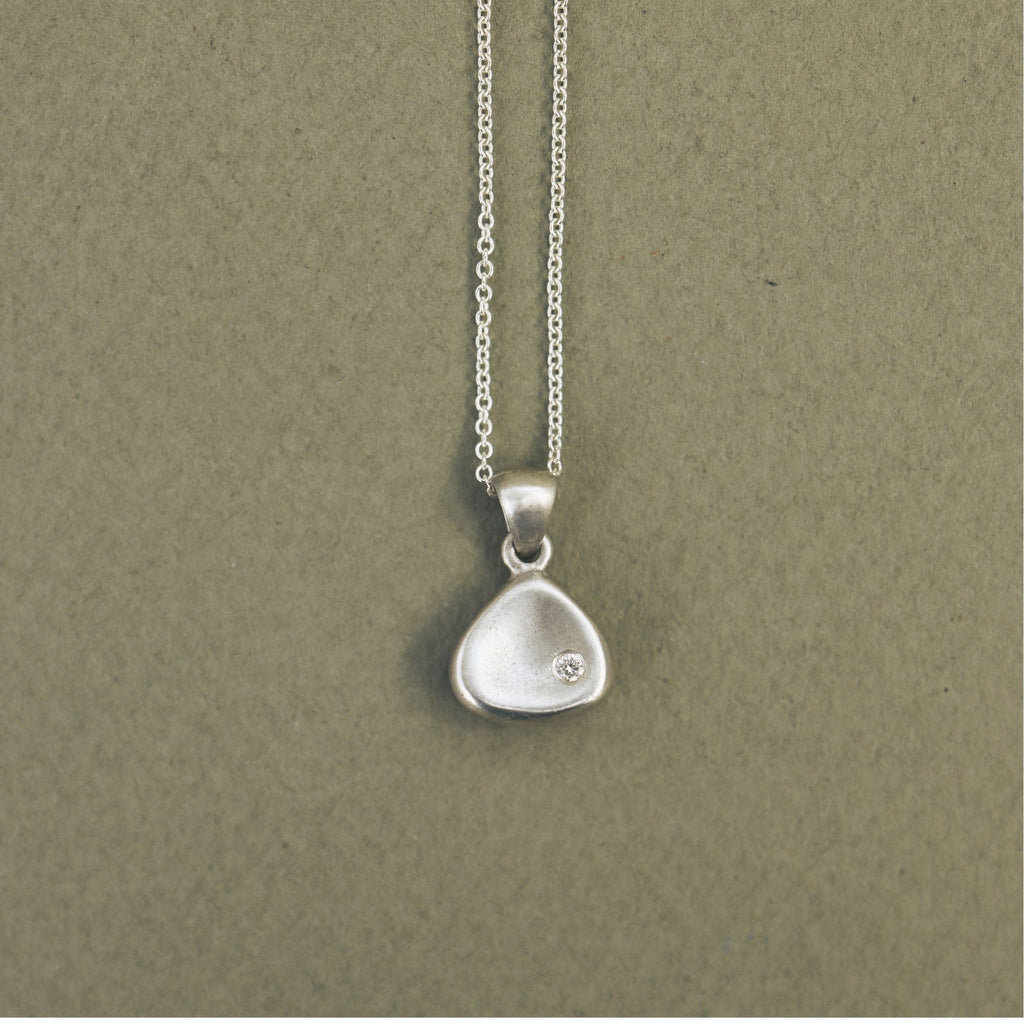 Handcrafted sterling silver triangle memory tag pendant with a natural diamond.